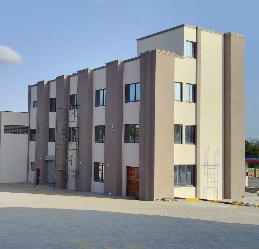Completed four-storey Jonerics Cargo Forwarders headquarters with grey and cream facade and paved yard